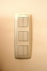 Wall switch with six buttons, grouped in pairs.