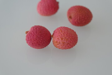 lychee fruit. red lychee fruit on white. lychee is a small tropical fruit from the soapberry family
