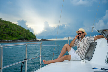Caucasian man enjoy outdoor luxury lifestyle on boat sailing at summer sunset. Handsome male...