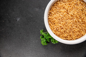 Brown rice whole grain cereal healthy product superfood fresh tasty gourmet food background on the table rustic food top view copy space keto and paleo diet vegetarian and vegan food