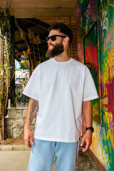 Fototapeta na wymiar White T-shirt on a bearded hipster in sunglasses — urban mockup for brands