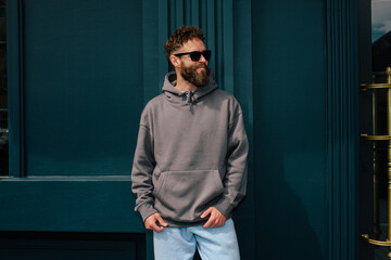 Bearded hipster in dark grey hoodie and sunglasses – urban apparel mockup
