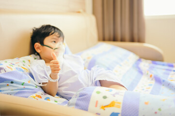 Boy 4 years old , inhale medication by inhalation mask to cure Respiratory Syncytial Virus (RSV) on hospital bed. Admitted patient boy inhalation therapy.