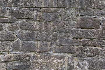 Wall of ancient castle bastion clad with stone blocks, fragment