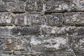 Wall of ancient castle bastion clad with stone blocks, fragment