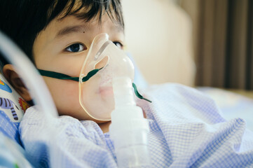 Boy 4 years old , inhale medication by inhalation mask to cure Respiratory Syncytial Virus (RSV) on...