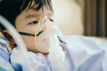 Boy 4 years old , inhale medication by inhalation mask to cure Respiratory Syncytial Virus (RSV) on...