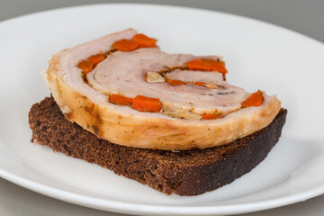 Partly bitten open sandwich with baked pork belly roll slice