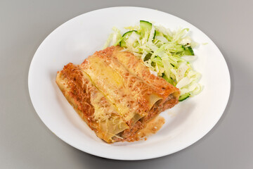 Baked pasta cannelloni stuffed with meat filling on dish