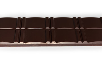 Dark chocolate bar on white background, side view close-up