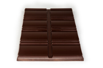 Dark chocolate bar, side view close-up in selective focus