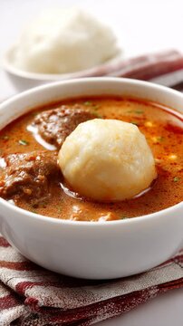 Ghanaian groundnut soup served with fufu ball during village soup day celebration