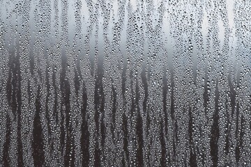 Condensation on Glass: A close-up shot reveals intricate patterns formed by water droplets and streaks of condensation on a glass surface, creating a moody and ethereal ambiance.