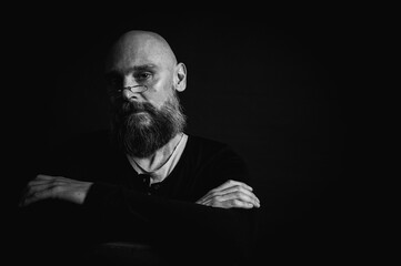 Black and white portrait, emotional bearded man in glasses, grimacing and grimacing at the camera....