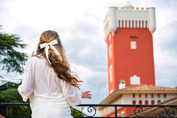 Woman posing at Chateau de Cremat with red building