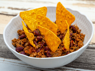 bowl of chili con carne topped with tortilla chips