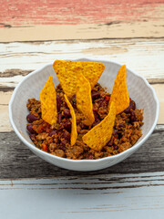 bowl of chili con carne topped with tortilla chips