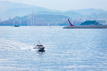 Busan, South Korea - pilot boat near container terminal, boat is approaching to the cargo ship with navigational pilot on board.