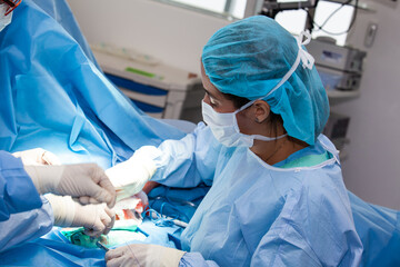 Female doctor performing a surgery. Orthopedic surgeon. Surgery and insurance concept.