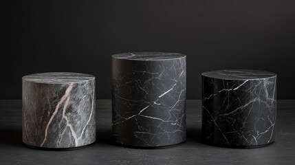 Three cylindrical marble pedestals on dark background.