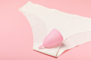 Menstrual cup on a bright background. Sanitary napkins, tampons and menstrual cup.Concept of critical days, menstruation.feminine hygiene product. Women health concept.Premenstrual syndrome.Copy space