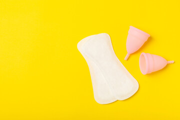 Menstrual cup on a bright background. Sanitary napkins, tampons and menstrual cup.Concept of critical days, menstruation.feminine hygiene product. Women health concept.Premenstrual syndrome.Copy space