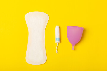 Menstrual cup on a bright background. Sanitary napkins, tampons and menstrual cup.Concept of critical days, menstruation.feminine hygiene product. Women health concept.Premenstrual syndrome.Copy space