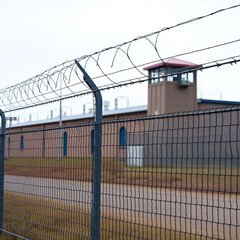 Fototapeta premium A fence covered in concertina wire surrounding a maximum security prison.