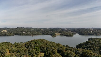 Aerial View of Passaúna Park in Curitiba, Brazil, with Lush Greenery and Wide Lake under Clear Sky