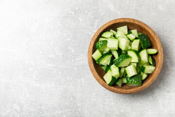 Cucumber on wooden background. Slice of cucumber on background. Fresh organic green cucumbers gherkin. Vegan. Salad ingredient. Farm vegetables. Cut vegetables with knife. Space for text. Copy space