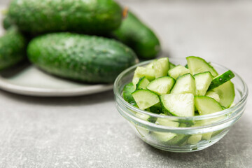 Cucumber on wooden background. Slice of cucumber on background. Fresh organic green cucumbers gherkin. Vegan. Salad ingredient. Farm vegetables. Cut vegetables with knife. Space for text. Copy space
