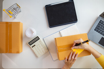 Asian businesswoman checking orders and shipping address for customers to deliver products according to the orders received via online shopping application. Online business idea via application