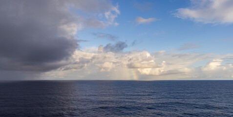 Scenic Ocean View with Clouds, Rainbow, and the Vast Pacific Horizon