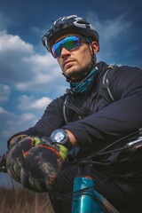 A man wearing a helmet and sunglasses sits on a bicycle