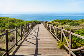 Wooden footbridge between dunes towards the Mediterranean Sea
