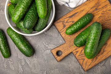 Cucumber on wooden background. Slice of cucumber on background. Fresh organic green cucumbers gherkin. Vegan. Salad ingredient. Farm vegetables. Cut vegetables with knife. Space for text. Copy space