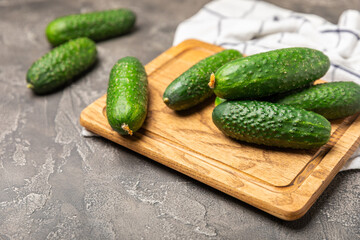 Cucumber on wooden background. Slice of cucumber on background. Fresh organic green cucumbers gherkin. Vegan. Salad ingredient. Farm vegetables. Cut vegetables with knife. Space for text. Copy space