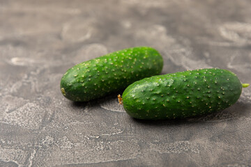 Cucumber on wooden background. Slice of cucumber on background. Fresh organic green cucumbers gherkin. Vegan. Salad ingredient. Farm vegetables. Cut vegetables with knife. Space for text. Copy space