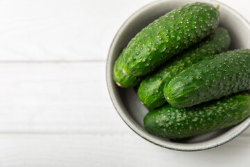 Cucumber on wooden background. Slice of cucumber on background. Fresh organic green cucumbers gherkin. Vegan. Salad ingredient. Farm vegetables. Cut vegetables with knife. Space for text. Copy space