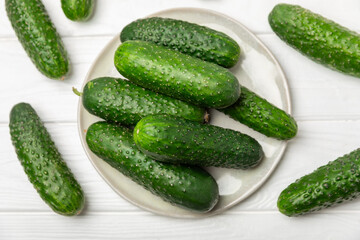 Cucumber on wooden background. Slice of cucumber on background. Fresh organic green cucumbers gherkin. Vegan. Salad ingredient. Farm vegetables. Cut vegetables with knife. Space for text. Copy space