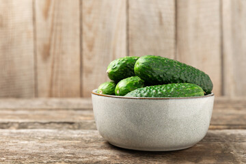 Cucumber on wooden background. Slice of cucumber on background. Fresh organic green cucumbers gherkin. Vegan. Salad ingredient. Farm vegetables. Cut vegetables with knife. Space for text. Copy space