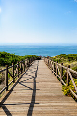 Obraz premium Wooden footbridge between dunes towards the Mediterranean Sea