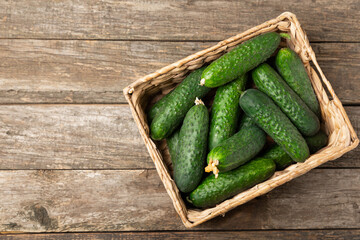 Cucumber on wooden background. Slice of cucumber on background. Fresh organic green cucumbers gherkin. Vegan. Salad ingredient. Farm vegetables. Cut vegetables with knife. Space for text. Copy space