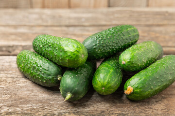 Cucumber on wooden background. Slice of cucumber on background. Fresh organic green cucumbers gherkin. Vegan. Salad ingredient. Farm vegetables. Cut vegetables with knife. Space for text. Copy space