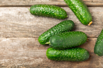 Cucumber on wooden background. Slice of cucumber on background. Fresh organic green cucumbers gherkin. Vegan. Salad ingredient. Farm vegetables. Cut vegetables with knife. Space for text. Copy space
