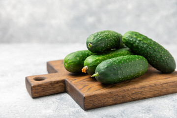 Cucumber on wooden background. Slice of cucumber on background. Fresh organic green cucumbers gherkin. Vegan. Salad ingredient. Farm vegetables. Cut vegetables with knife. Space for text. Copy space