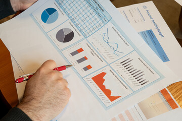 Businessman analyzing financial charts and personal budget report