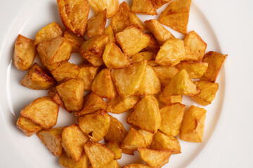 Crispy golden fried potato cubes closeup
