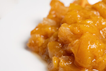Closeup of pineapple sauce on white plate
