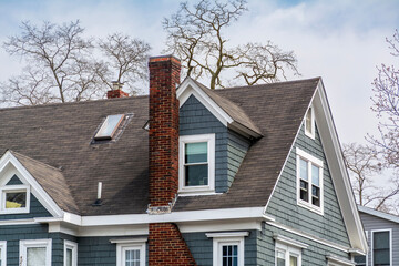 Charming pitched-roof house with brick chimney and gabled dormer in Brighton, Massachusetts, USA
